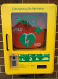 Wall mounted defibrillator in bright yellow wall box